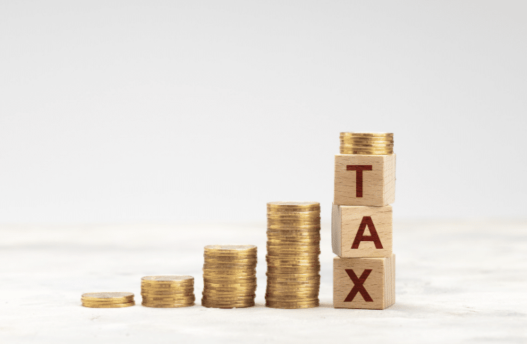 picture with stacked coins and blocks with the word tax on them